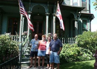 Guest Photos- Two couples standing outside of Queen Victoria below flags.
